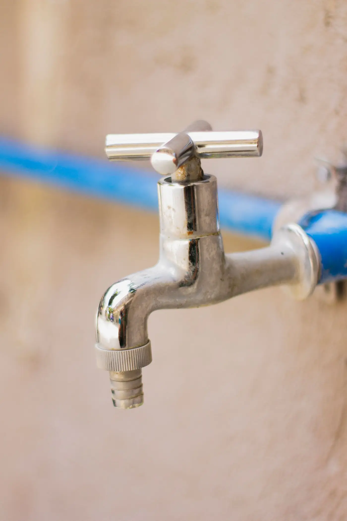 Fuite d’eau à Toulouse : robinet extérieur raccordé à un tuyau bleu